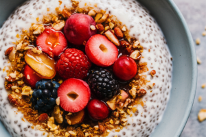 Chia pudding topped with fresh berries, coconut flakes, and a drizzle of honey.