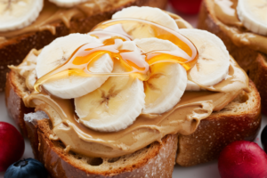 Toasted bread topped with creamy peanut butter, banana slices, and a drizzle of honey.