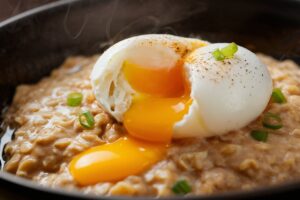 Warm savory oatmeal topped with a perfectly poached egg and garnished with herbs.