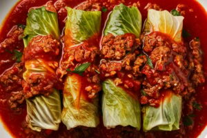 Delicious cabbage rolls stuffed with rice and meat, topped with savory tomato sauce.