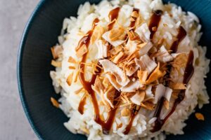 Creamy coconut rice pudding topped with a sprinkle of cinnamon and toasted coconut flakes.