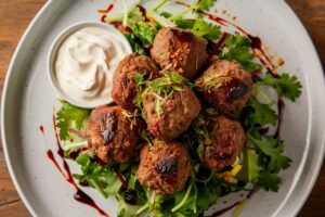 Tender lamb kofta skewers served with a creamy yogurt sauce and fresh herbs.